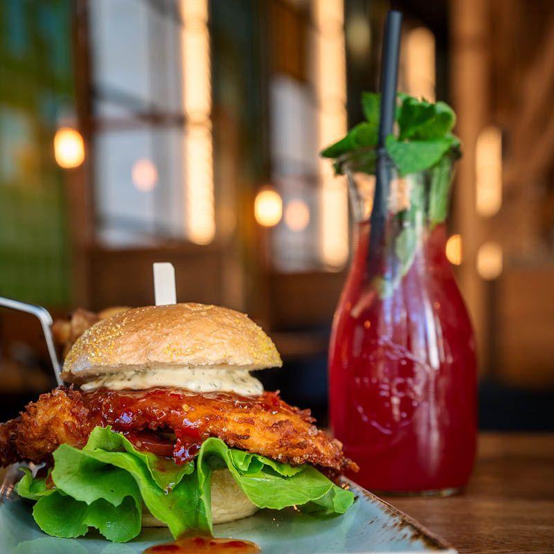 Burger mit Hähnchenpatty und Salat angerichtet auf einem Teller in der Burgerei Dresden